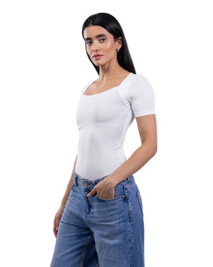 A woman modeling a fitted white short-sleeve scoop-neck top paired with blue jeans against a plain white background.