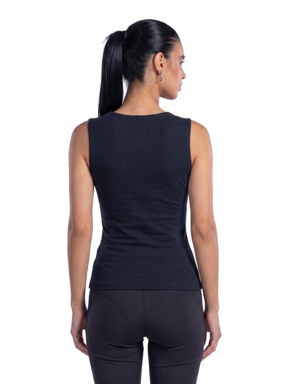 A woman shown from the back wearing a sleeveless black athletic top and black leggings against a plain white background.