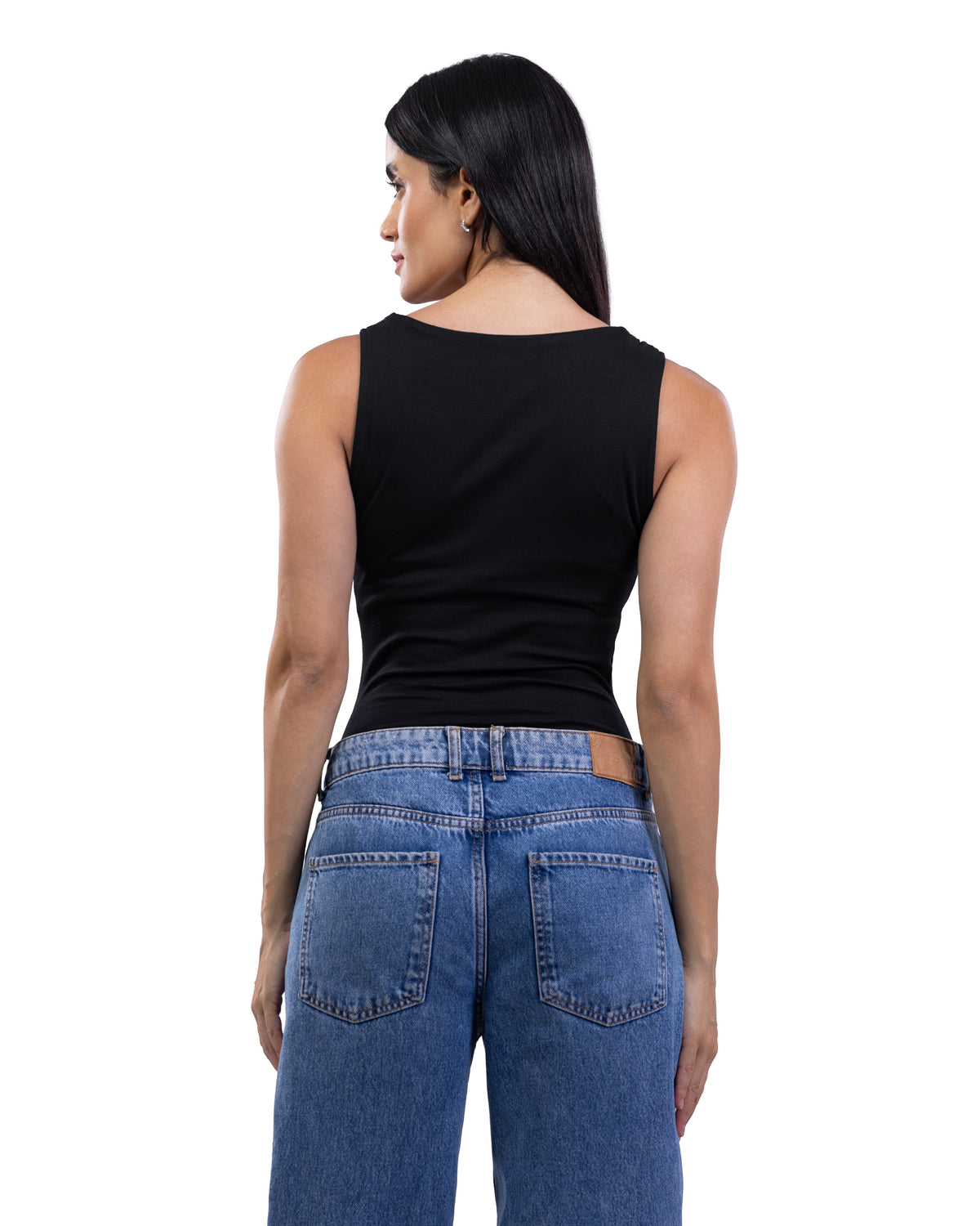 A woman shown from the back wearing a fitted black sleeveless top and blue jeans against a plain white studio background.