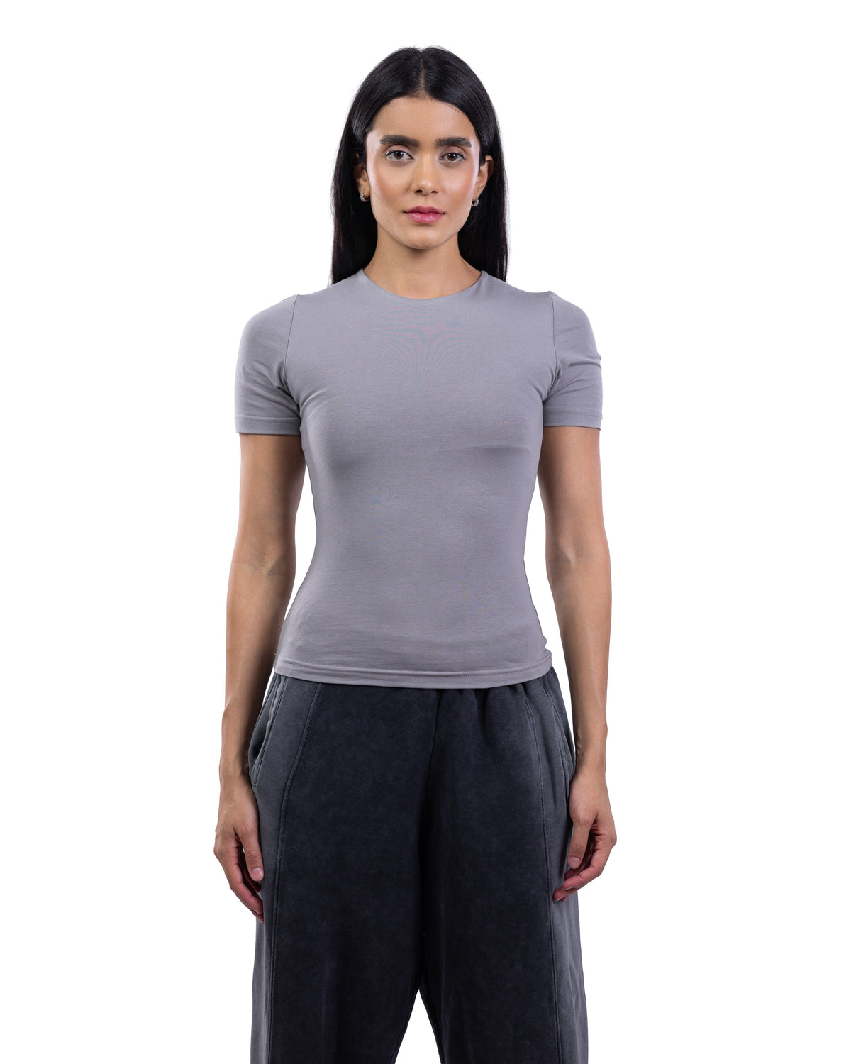 A woman modeling a fitted short-sleeve crewneck top in light gray, paired with dark gray wide-leg pants, against a plain white background.