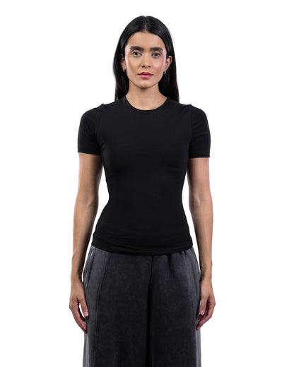 A woman modeling a fitted black short-sleeve crewneck top with dark gray wide-leg pants, standing against a plain white background.
