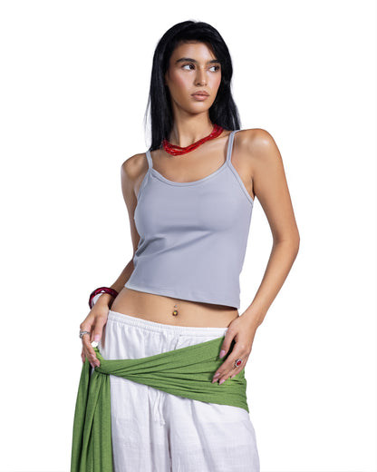 A woman modeling a light gray ribbed crop top with white pants and a green wrap, set against a plain white background.