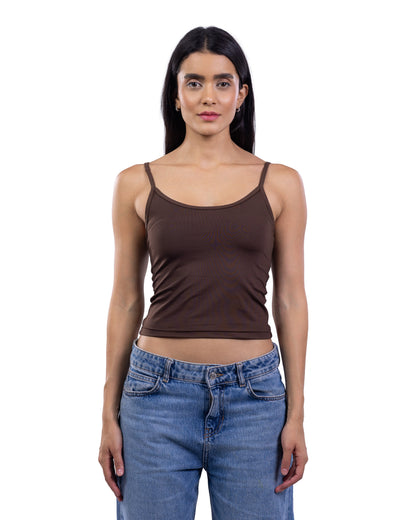 A woman modeling a dark brown ribbed spaghetti-strap tank top paired with blue jeans, shot against a solid white background.
